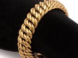 une photo en gros plan d'un bracelet en or posé sur une serviette