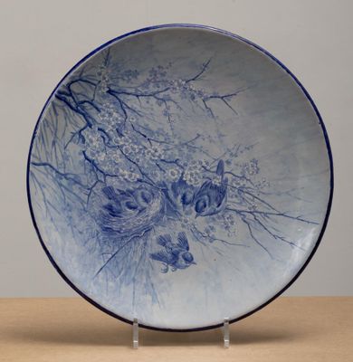 une assiette bleue et blanche posée sur un support, sur une table