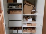 une armoire blanche avec beaucoup de boîtes et de cartons dessus