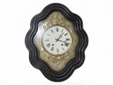 une horloge noire et dorée avec des chiffres romains