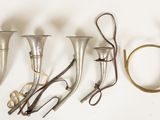 five brass instruments that are lined up on a wall
