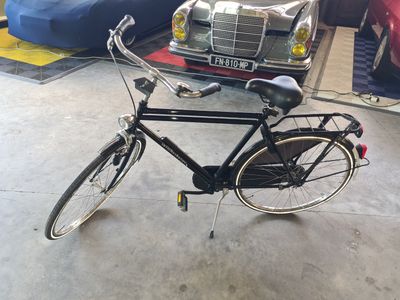 a bicycle that is parked next to a car in a garage