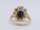 a close up of a gold ring with a blue stone