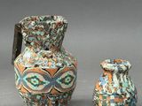 two vases and a small vase sitting next to each other on a gray surface