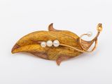 une image représentant une broche ornée de deux perles sur une feuille
