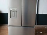 a silver refrigerator sitting on a pallet in a warehouse