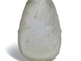 a white vase that has a leaf design on it