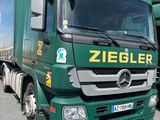 deux camions verts garés l'un à côté de l'autre sur un parking