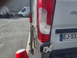 a white van parked in a parking lot with a red cone in front of it