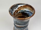 a close up of a vase on a white surface
