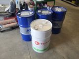 several barrels of oil sitting on the floor in a warehouse