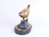 sculpture of a bird sitting on a rock on a white background