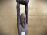 a statue of a man holding a bird on his head