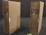 pair of vintage books in cardboard boxes on a black surface