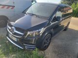 une camionnette noire garée sur un parking à côté d'une camionnette blanche