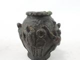 a small vase with a lid sitting on a white surface