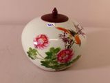 a white vase with a bird and flowers painted on it