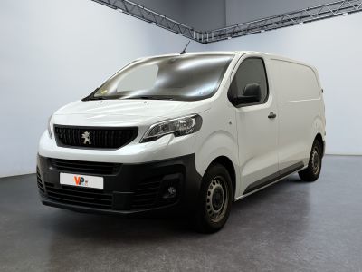 La petite camionnette blanche est garée dans une grande pièce.