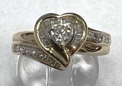 a heart shaped diamond ring on a clear glass stand