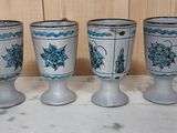 four blue and white vases sitting on top of a marble counter top