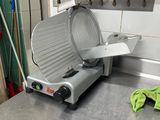 a large metal cutting machine on a counter in a kitchen