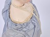a doll that is wearing a blue dress and a necklace