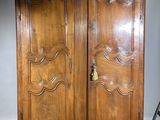 a large wooden cabinet with a door on top of it