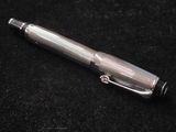 un stylo argenté posé sur une surface noire