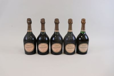 cinq bouteilles de champagne alignées les unes à côté des autres sur une surface blanche