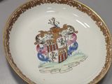 a plate with a coat of arms on it on a table
