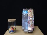 a glass jar filled with dice and a box of cards on a table