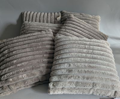several pillows are stacked on top of each other on a white surface