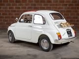 a small white car parked in front of a brick wall