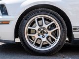 a close up of a white mustang parked in a parking lot