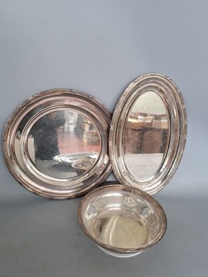 deux plats en métal argenté avec un miroir posé sur une table