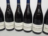 six bottles of wine are lined up in a row on a table