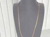 gold chain necklace and bracelet set on a mannequin display