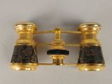 gold plated pair of binoculars with black and brown marbles