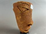 a small statue of a face with a tag on it