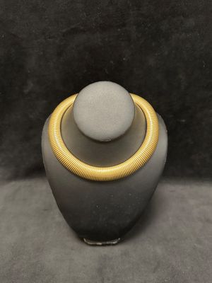 a close up of a necklace on a mannequin on a table