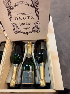 plusieurs bouteilles de champagne dans un coffret en bois posé sur une table