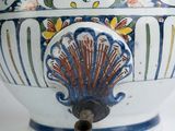 a white vase with a blue and yellow design on it