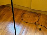 une lampe noire posée sur un plancher en bois
