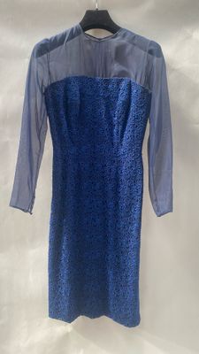 a blue dress hanging on a hanger on a white wall
