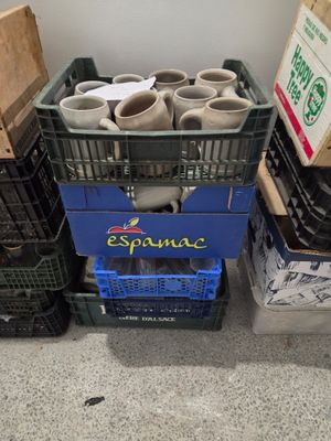 de nombreuses boîtes et caisses contenant des tasses, posées par terre