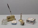 une table blanche sur laquelle se trouvent divers objets, ainsi qu'un stylo et un encrier
