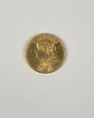 gros plan d'une pièce d'or sur une surface blanche