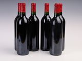 three bottles of red wine sitting next to each other on a white surface