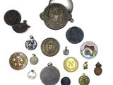 many different types of buttons and charms on a white surface