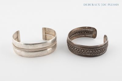 une paire de bracelets manchette en argent sur fond blanc